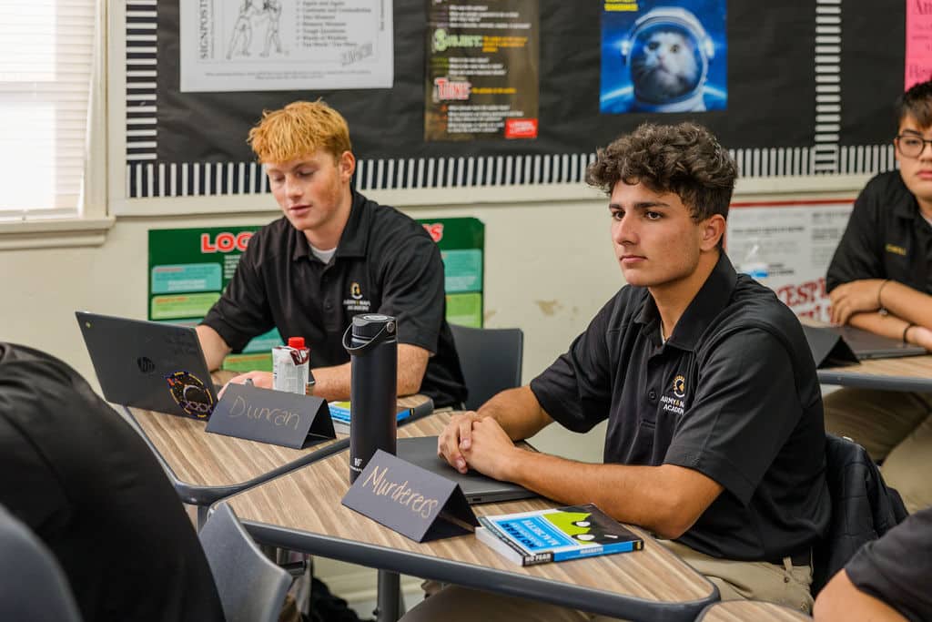 Students in a classroom sit at desks, focused on a lesson