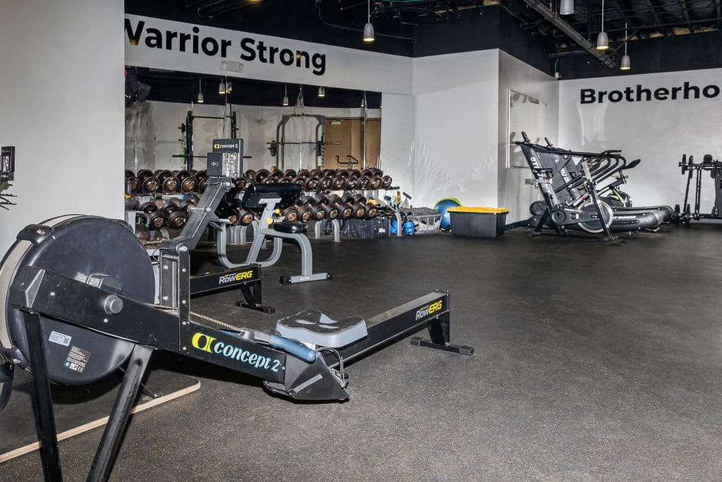 gym interior featuring a rower machine and various weights