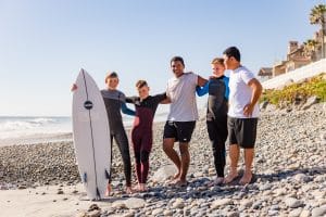 five boys standing with a surfing board