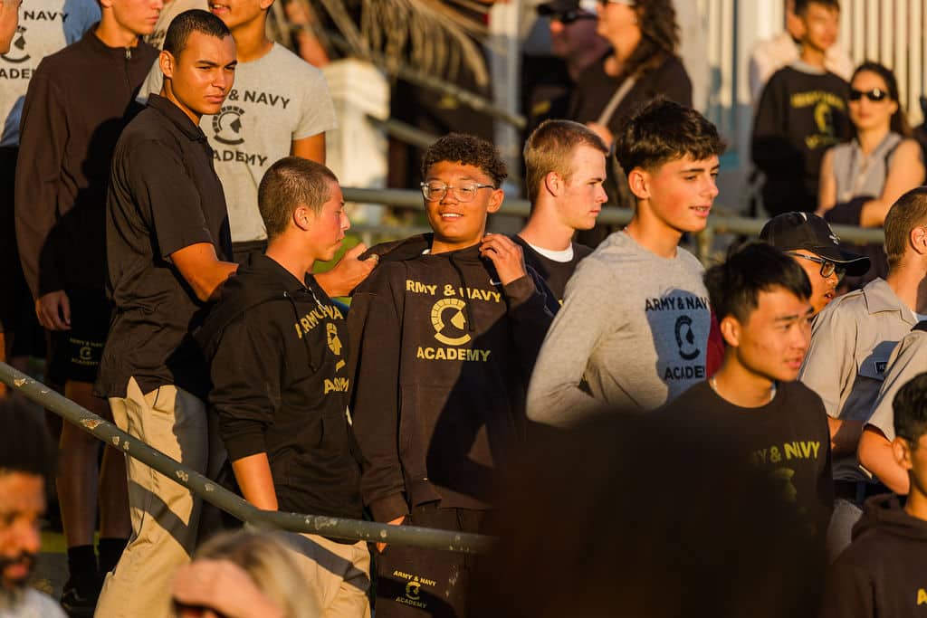 A group of young people in matching "Army & Navy Academy" shirts