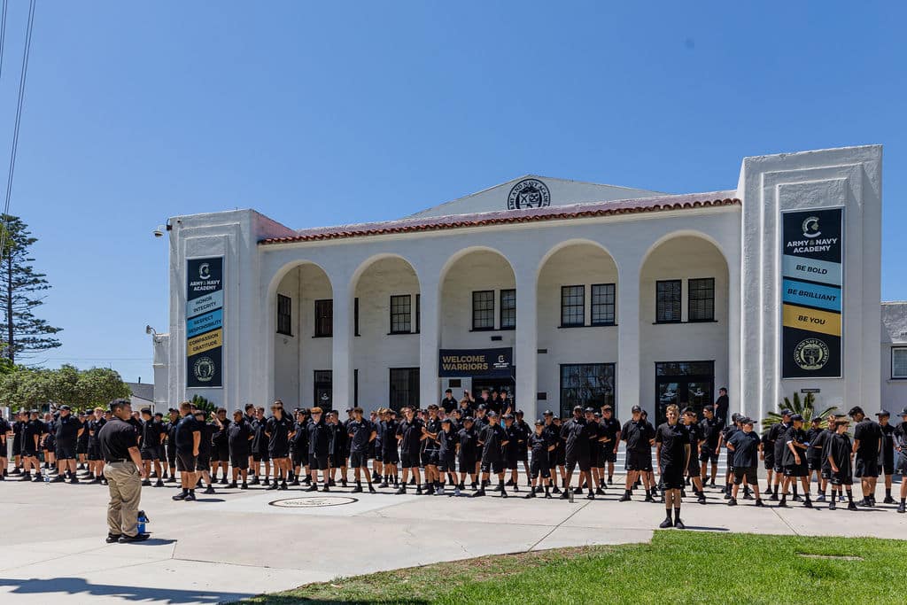 group of students gathered in front of a large building